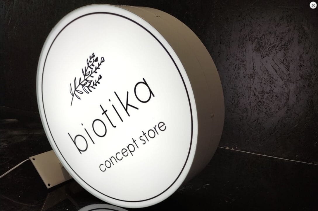 Podświetlany semafor z czarnym logo Biotika na białym tle.